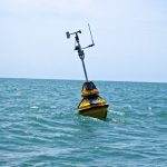 An environmental data buoy floating in the water.