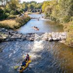 People kayaking down the Huron River in Ann Arbor, Michigan.