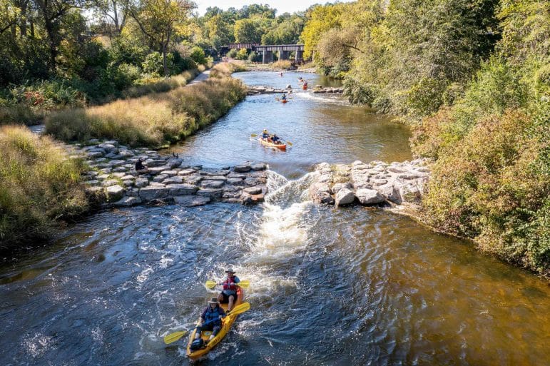 People kayaking down the Huron River in Ann Arbor, Michigan.