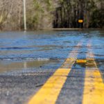 Close-up view of water covering part of a road due to flooding