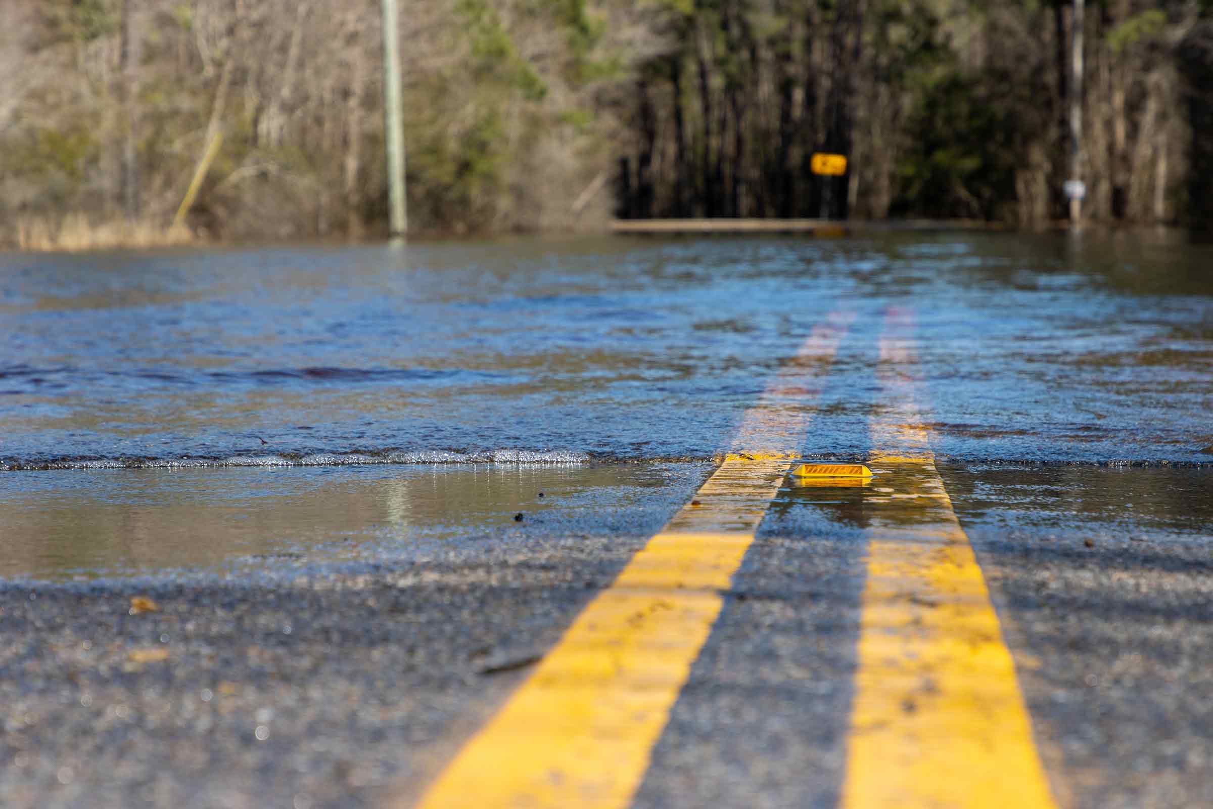 Close-up view of water covering part of a road due to flooding