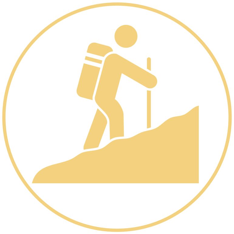 Icon in yellow of a human figure hiking up a mountain with a circle border around it.