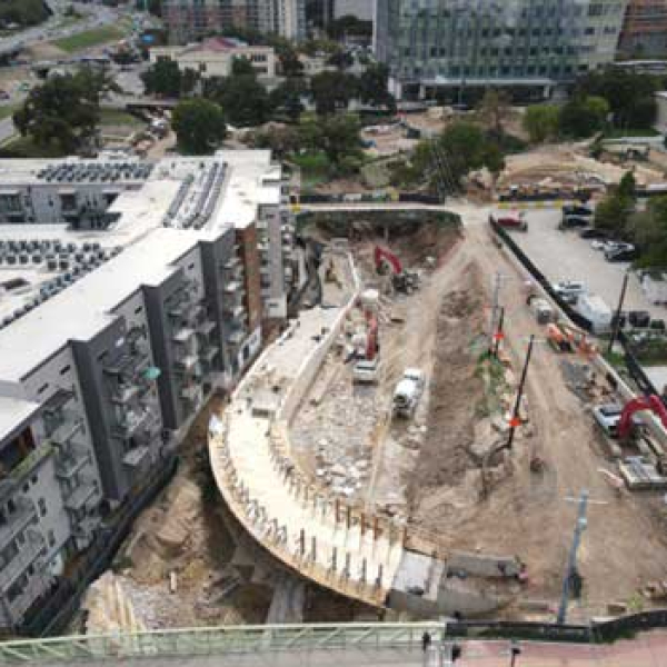 Construction of the Arc Bridge along a corridor next to development.